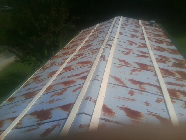 Rusted metal roof panels with new wood purlins before replacement — Storm Damage Roof Repair in Leland by Roofing Brothers