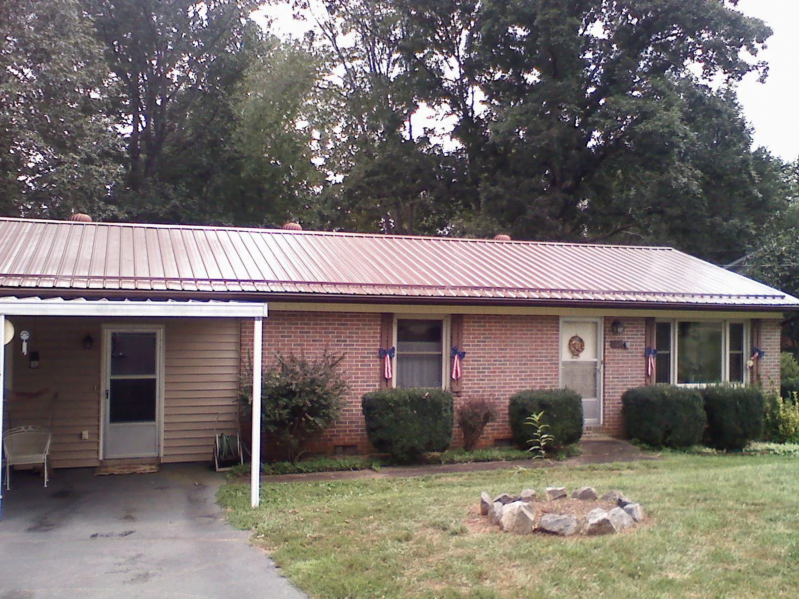Bronze metal roof and carport on a brick ranch home — Roof Repair work by our crew in Leland