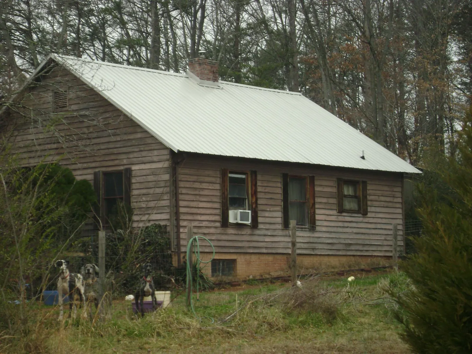 White metal roof on an old wood sided farmhouse, from a Metal Roof Installation job in Leland